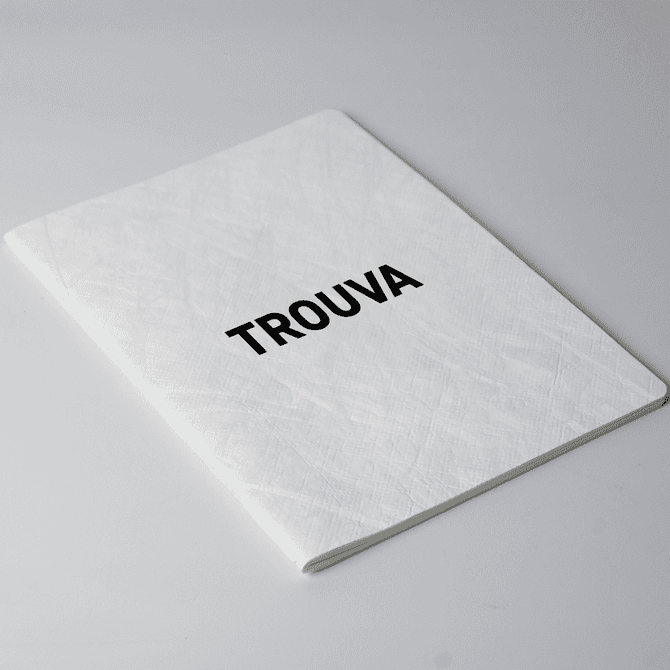 A white A5 notebook with a textured cover and a black logo on the front.