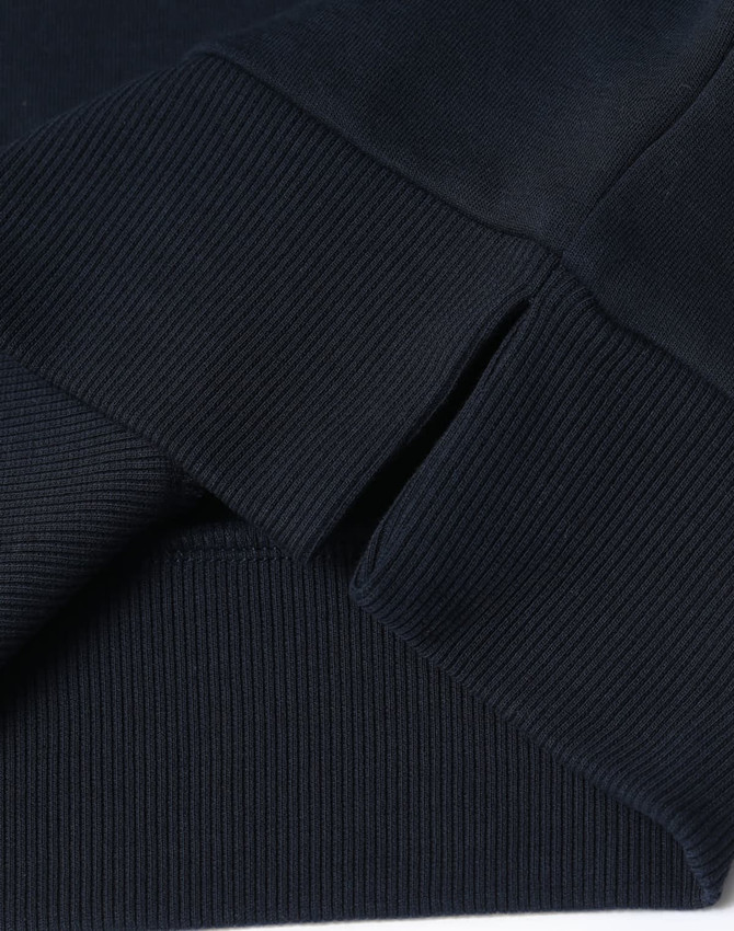 A dark navy crew neck sweater featuring ribbed cuffs and hem, displaying a logo on the fabric.
