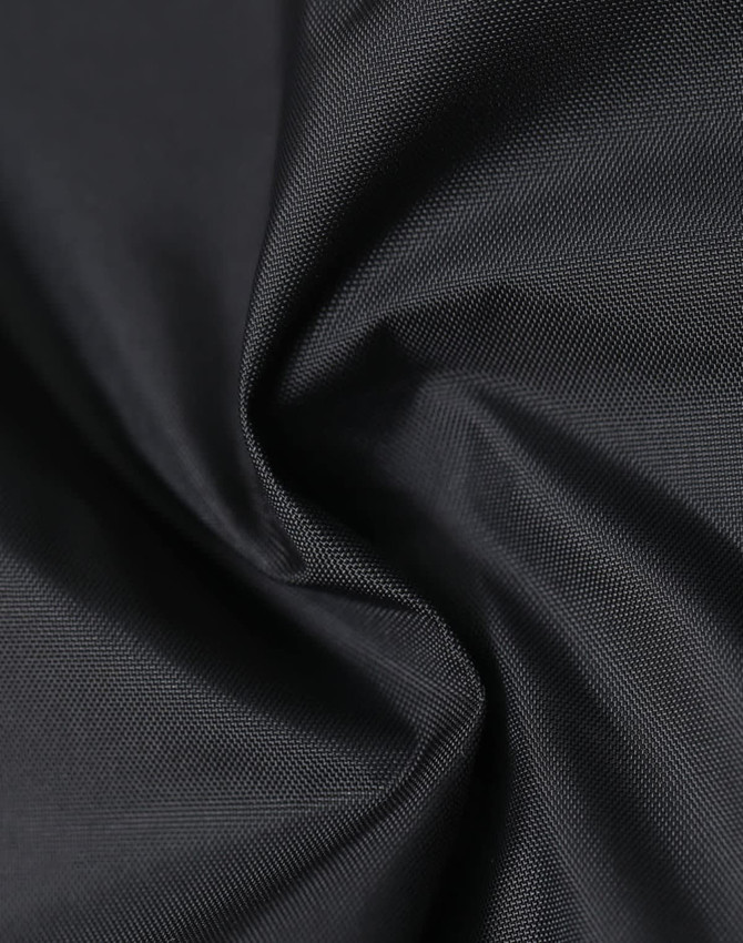 A close-up of lightweight nylon fabric in black, showing a smooth, waterproof texture. There is a logo visible.