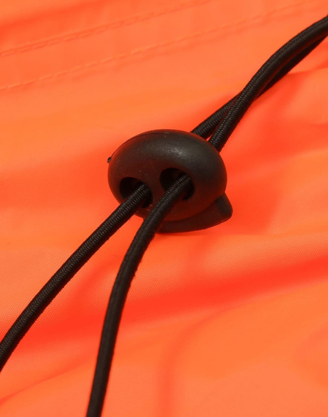 An orange lightweight nylon waterproof rain pant detail featuring a black toggle and cord adjustment.