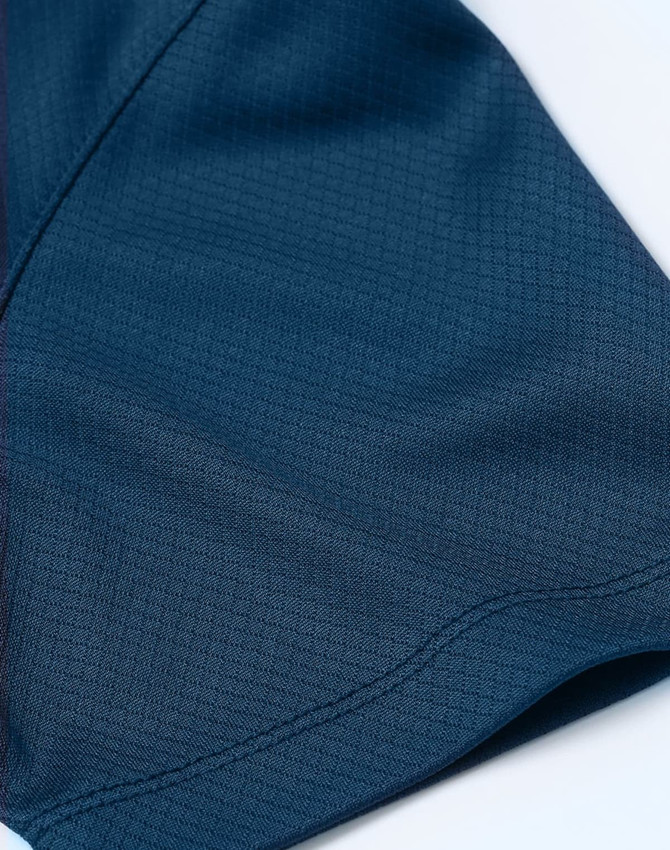 A close-up of a navy blue jacquard knit fabric, featuring a smooth texture and intricate pattern.