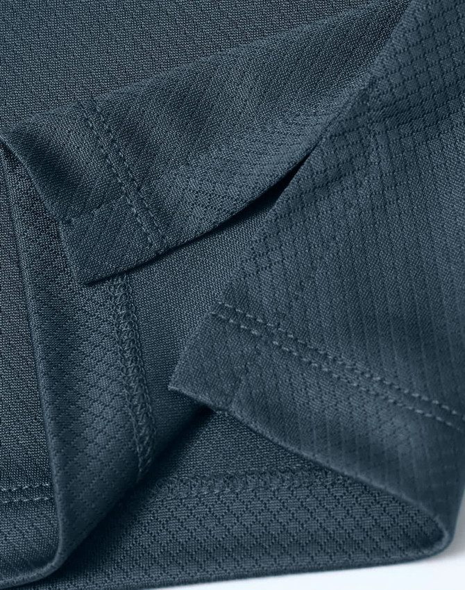 A close-up of a dark grey textured fabric showcasing the details of a sustainable knit polo shirt.