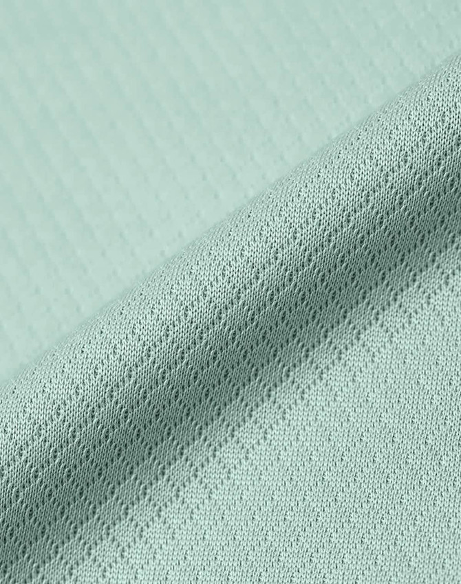 A close-up of a light mint green jacquard knit fabric with a textured pattern. The material appears soft and sustainable.