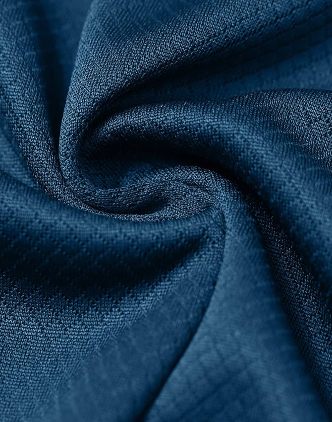 A close-up of a textured navy blue fabric, showcasing its jacquard knit pattern.