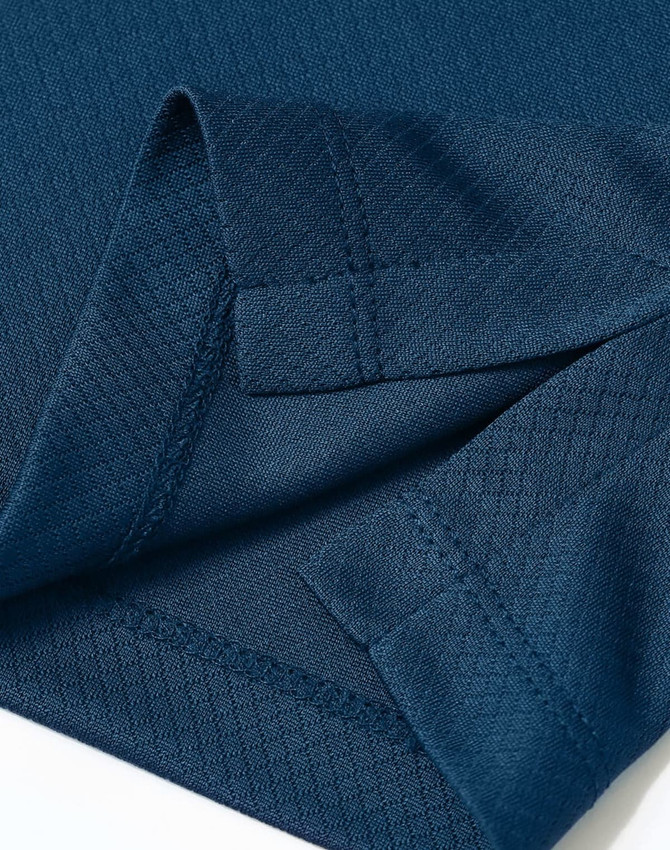 A close-up of a navy blue sustainable jacquard knit polo, highlighting the fabric texture and stitching details.