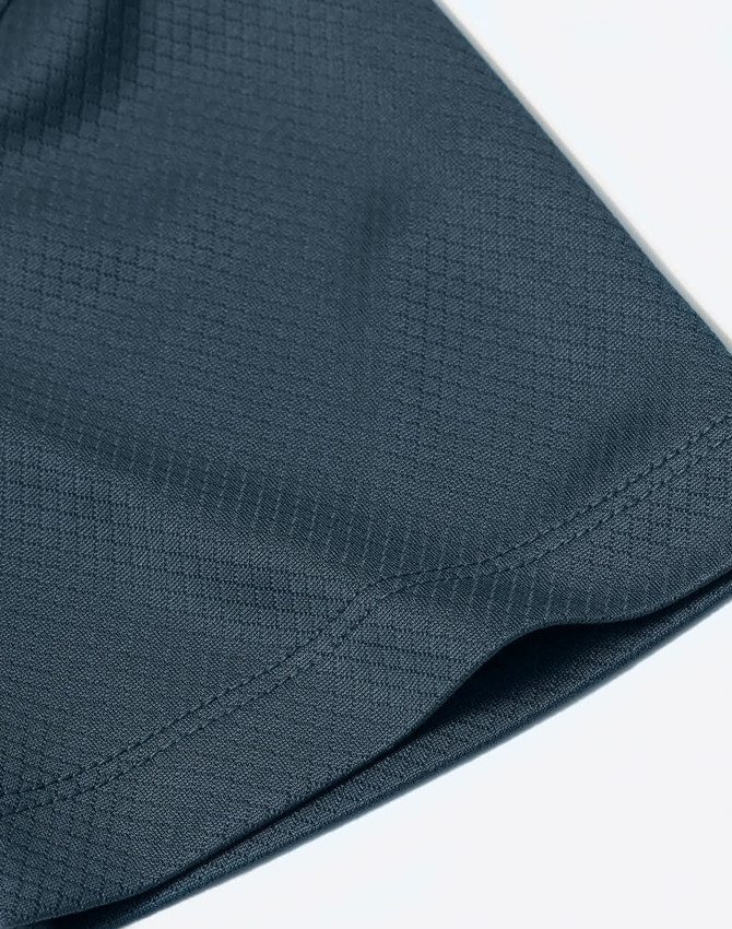 A close-up of a dark blue fabric featuring a jacquard knit pattern. The image highlights the texture and stitching details.