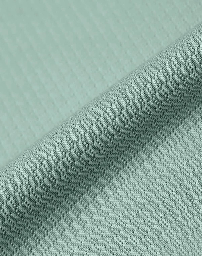 A close-up of a textured fabric in light green, showcasing a jacquard knit pattern. The image features a subtle sheen.