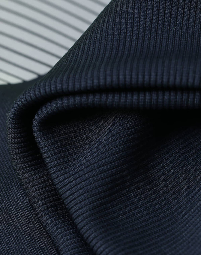 A close-up of textured, dark navy fabric with a ribbed pattern, showcasing its soft and flexible quality.