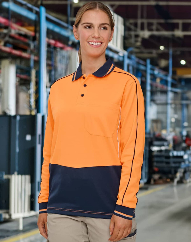 A long-sleeve polo in hi-vis orange and navy, featuring a logo, set in an industrial environment.