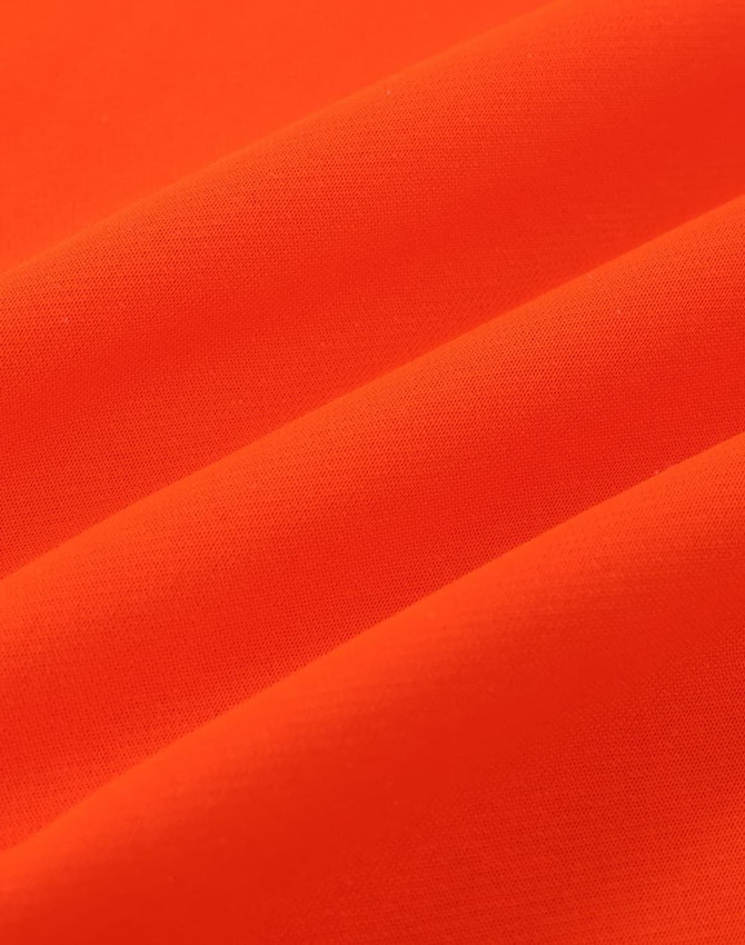 An orange fabric with a smooth texture, featuring folds that highlight its soft appearance.