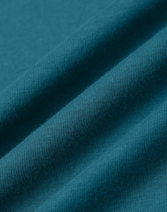A close-up of teal premium cotton fabric with a soft texture, featuring folds and a smooth finish.