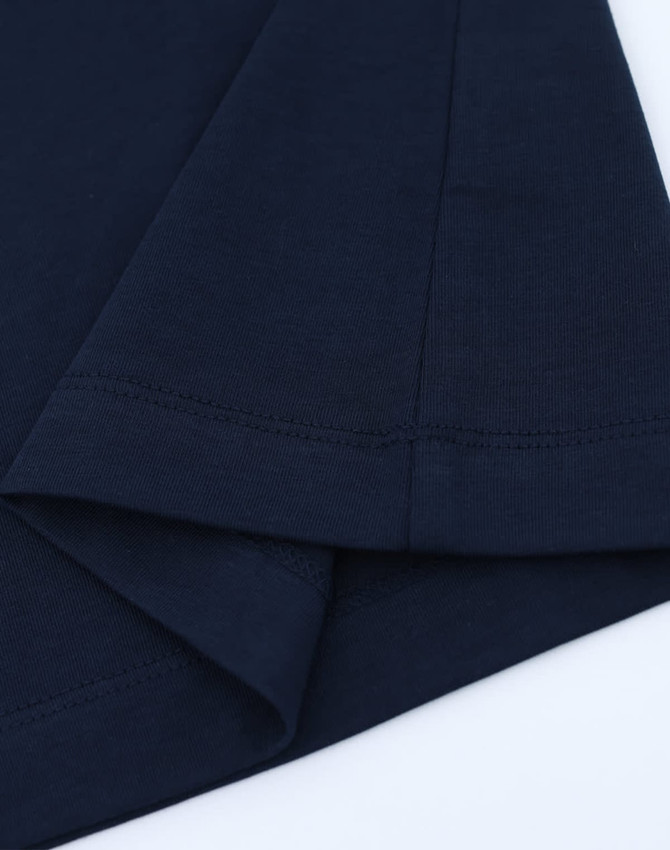 A navy blue long-sleeve cotton tee shirt featuring a hemmed finish and a logo on the sleeve.