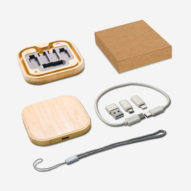 A bamboo wireless charger and a cable kit in a kraft box, featuring grey and silver connectors and a grey strap.