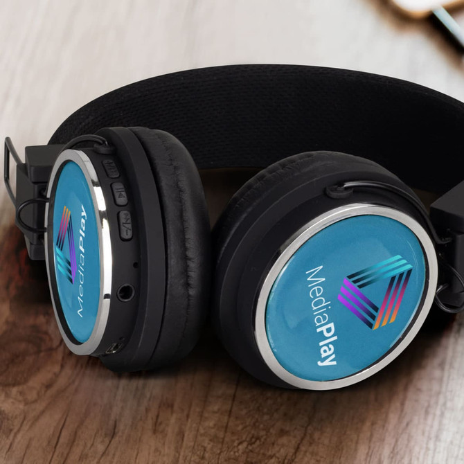 Bluetooth headphones in black with blue accent and a logo, displayed on a wooden surface.