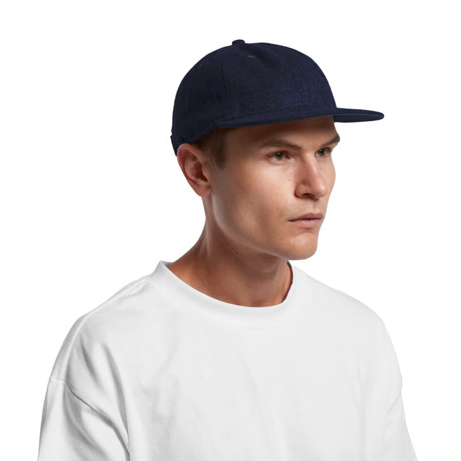A navy Class Wool Cap with a flat brim, worn by a model in a white t-shirt. The cap features a logo.
