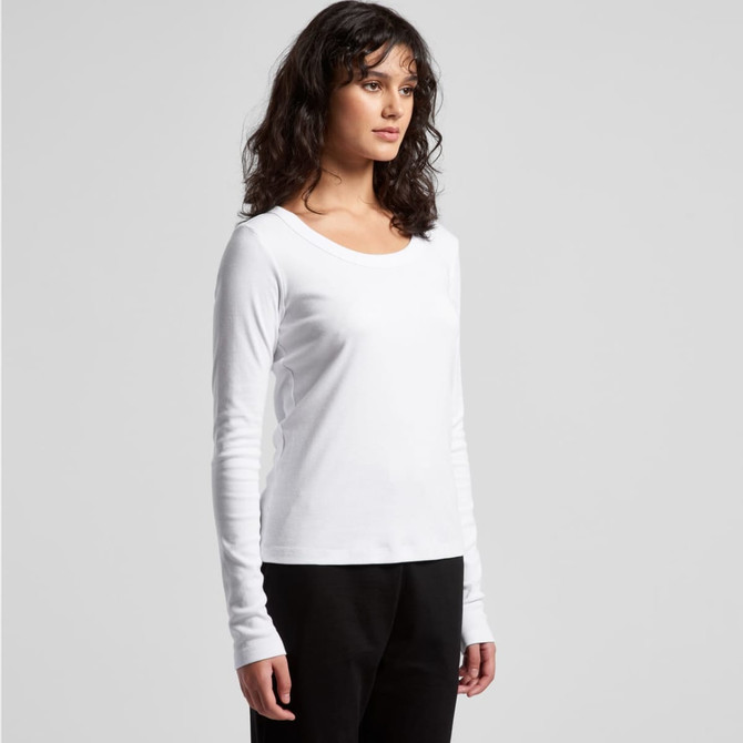 A long-sleeve, white organic tee featuring a scoop neck and a fitted silhouette. The model is styled with black pants.