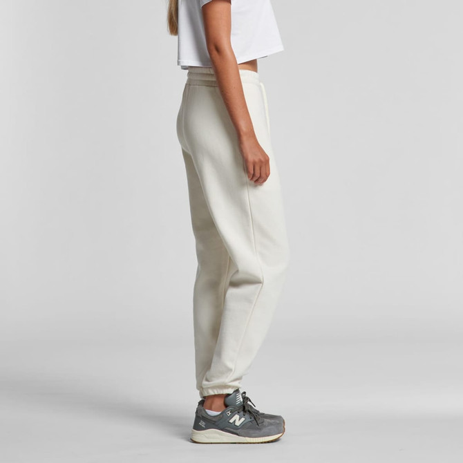 Light-coloured track pants featured on a model, styled with a cropped white top and grey sneakers, featuring a logo.