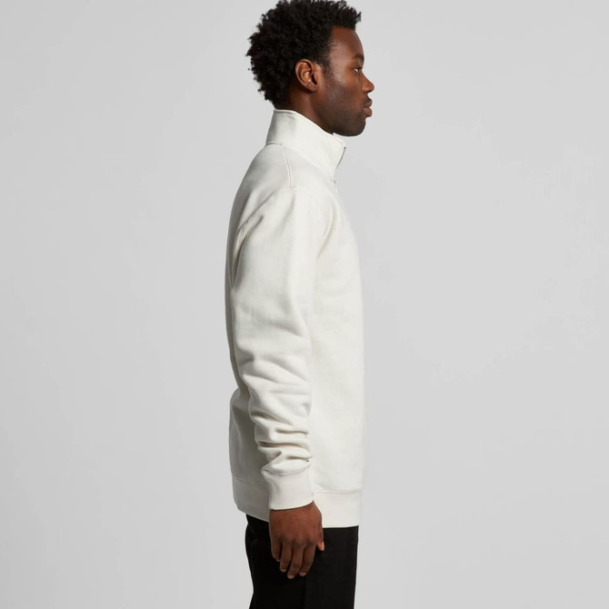 A side view of a cream-coloured half zip crew jumper, featuring a high collar and relaxed fit.