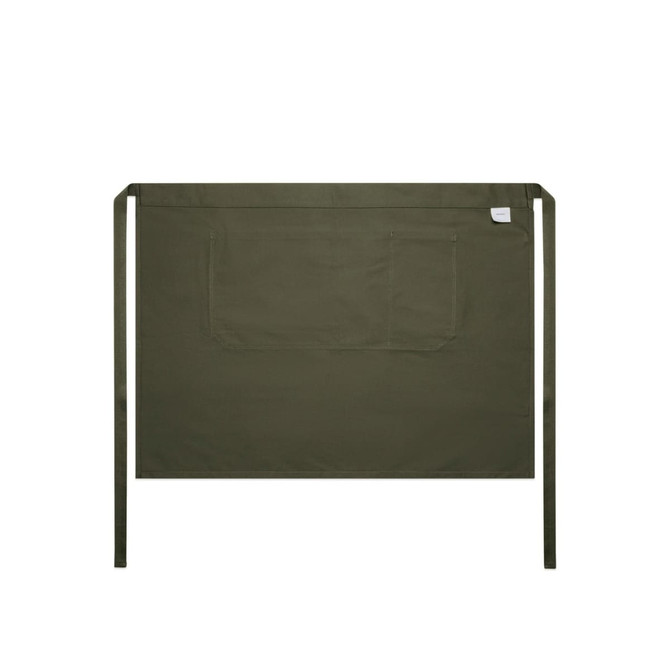 A green half apron with a large front pocket and ties on each side, featuring a branding label.