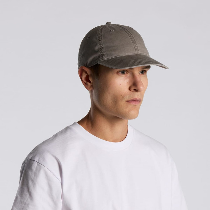 A faded grey cap with a curved brim, worn by a person in a plain white t-shirt. Features branding on the side.