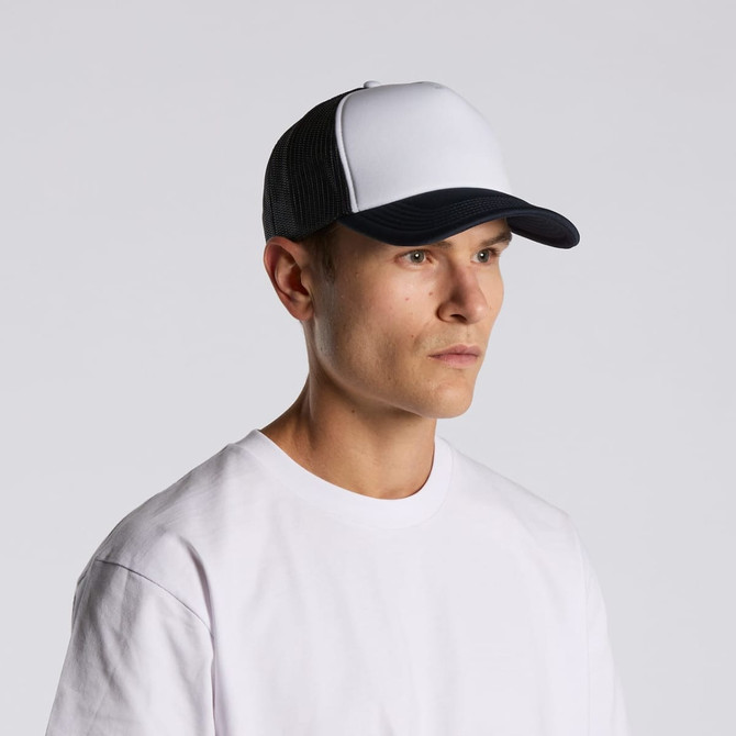 A two-tone trucker cap featuring a white front and black mesh back, worn by a model in a white T-shirt.