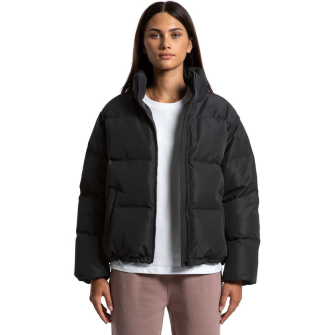 A puffer jacket in black, featuring a zip front and a relaxed fit, worn by a model against a plain background.