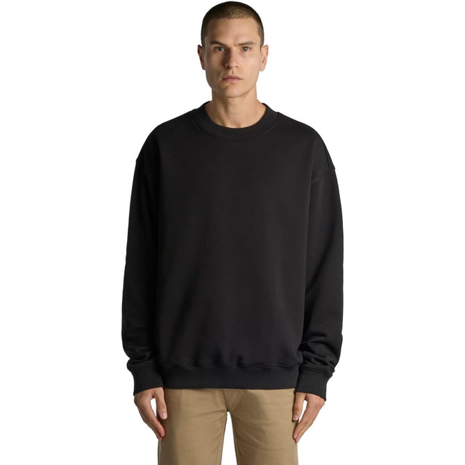 A black sweater with a relaxed fit, featuring a round neck and long sleeves. The model stands facing forward.