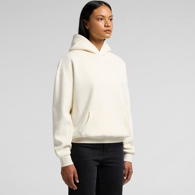 A cream hoodie with a front pocket and a hood, displayed on a model against a plain background.