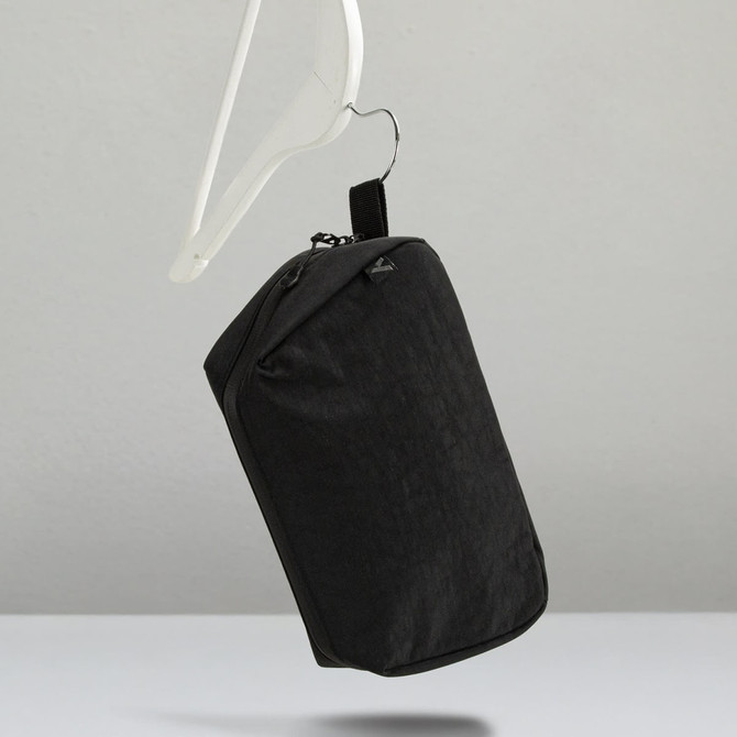 A black toiletry bag with a hanging hook, featuring a simple design and a logo.