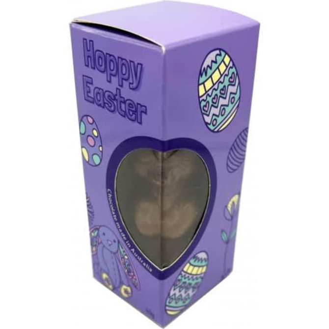 A purple box with Easter-themed designs contains a chocolate Easter bunny inside a clear window.