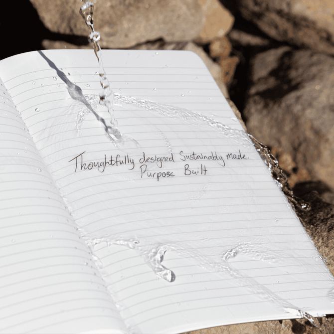 A softcover A5 notebook with lined pages and water splashes, featuring a logo on the cover.