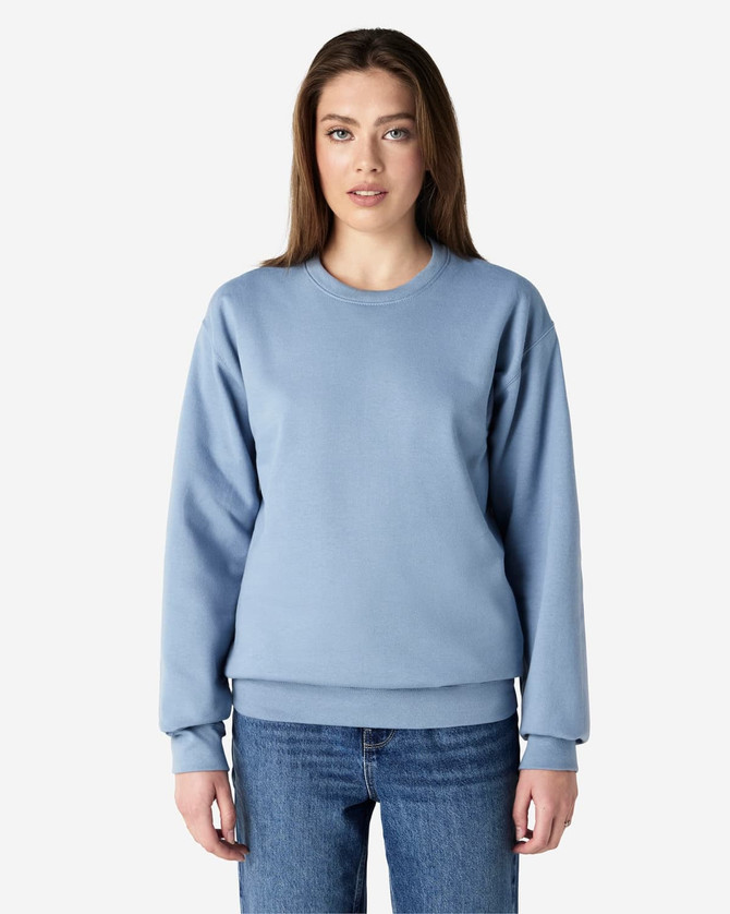 A light blue Gildan Softstyle adult sweatshirt worn by a woman, featuring a classic crew neck and long sleeves.