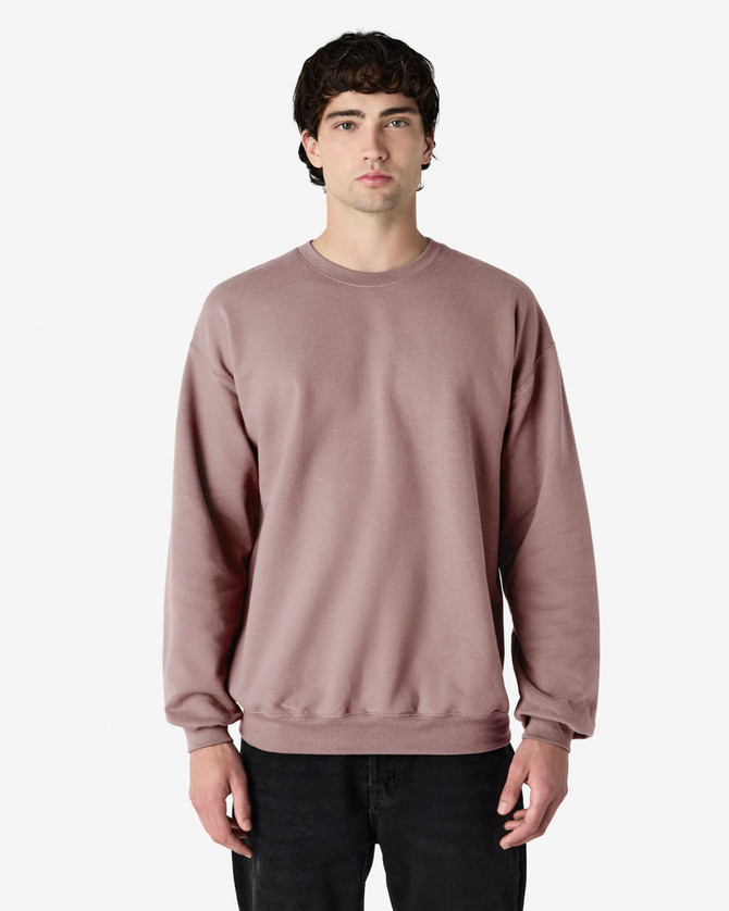 A plain, long-sleeved sweatshirt in a muted mauve colour, featuring a crew neck and relaxed fit. It has a logo.