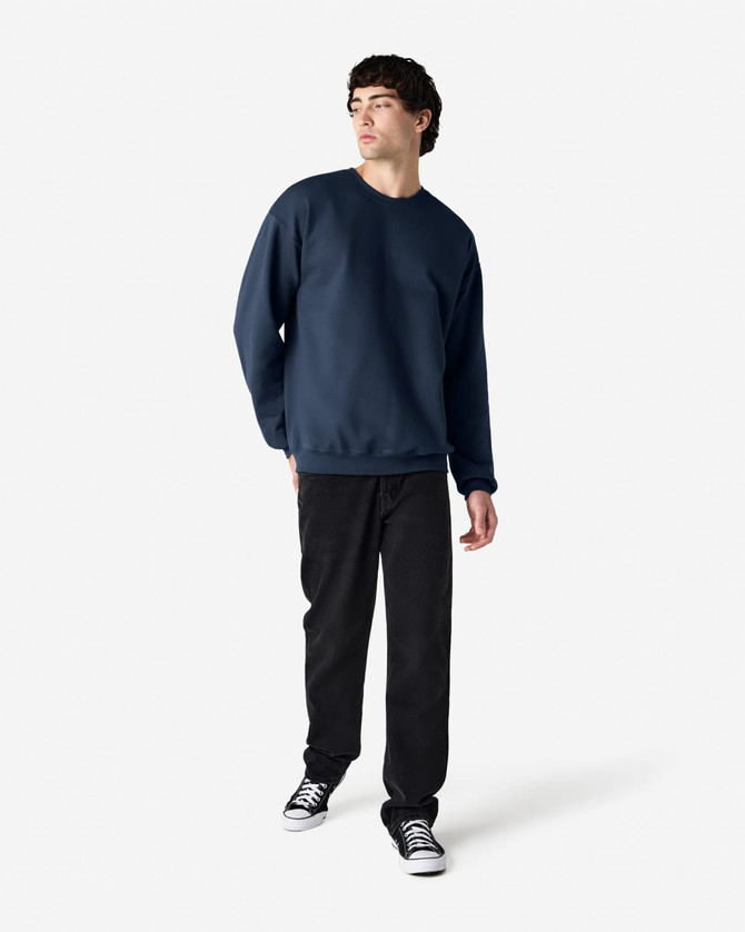 A navy blue Gildan Softstyle adult sweatshirt, shown on a model paired with black pants and sneakers.