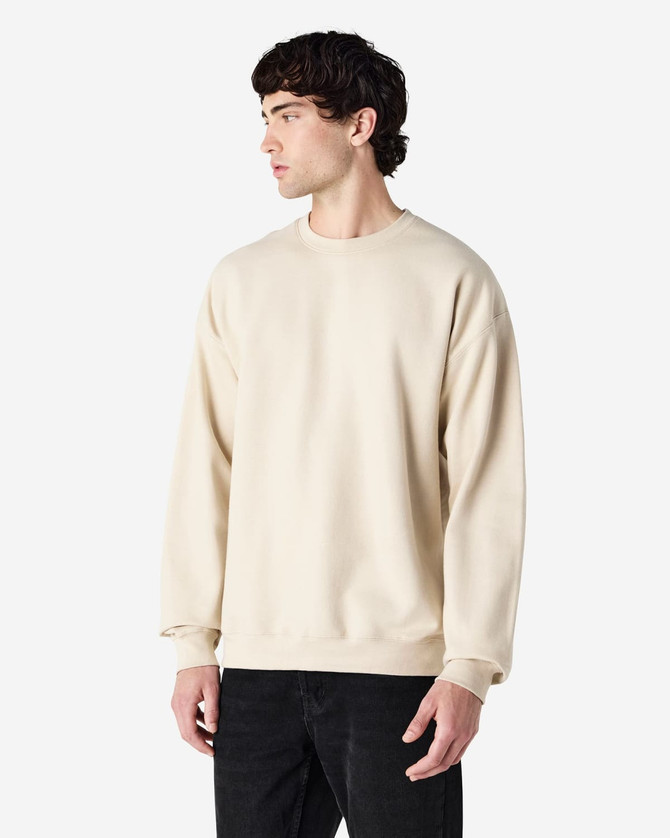 A beige Gildan Softstyle adult sweatshirt is displayed on a model, with a plain design and a visible logo.