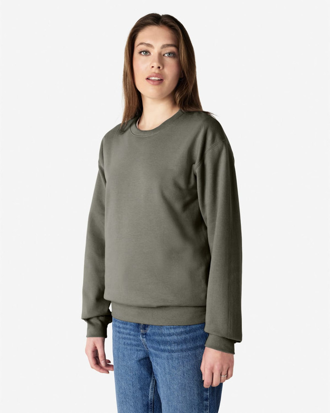 A green Gildan Softstyle adult sweatshirt displayed on a model, featuring long sleeves and a classic fit.