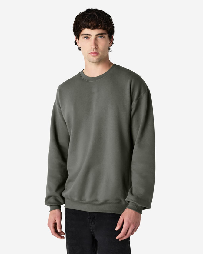A dark green Gildan Softstyle adult sweatshirt on a model, featuring a casual design and long sleeves.
