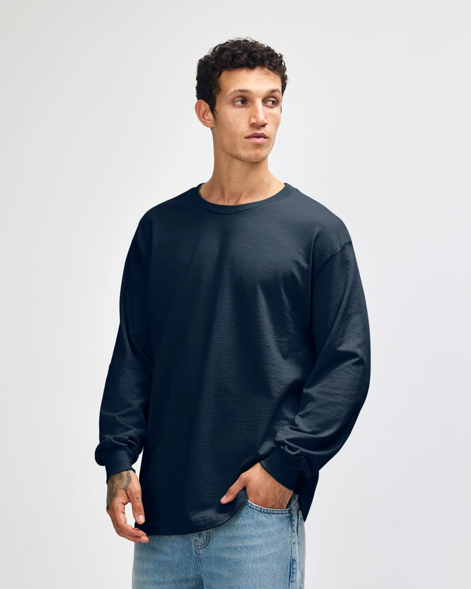 A black unisex long sleeve t-shirt displayed on a model, featuring a relaxed fit and a logo on the chest.