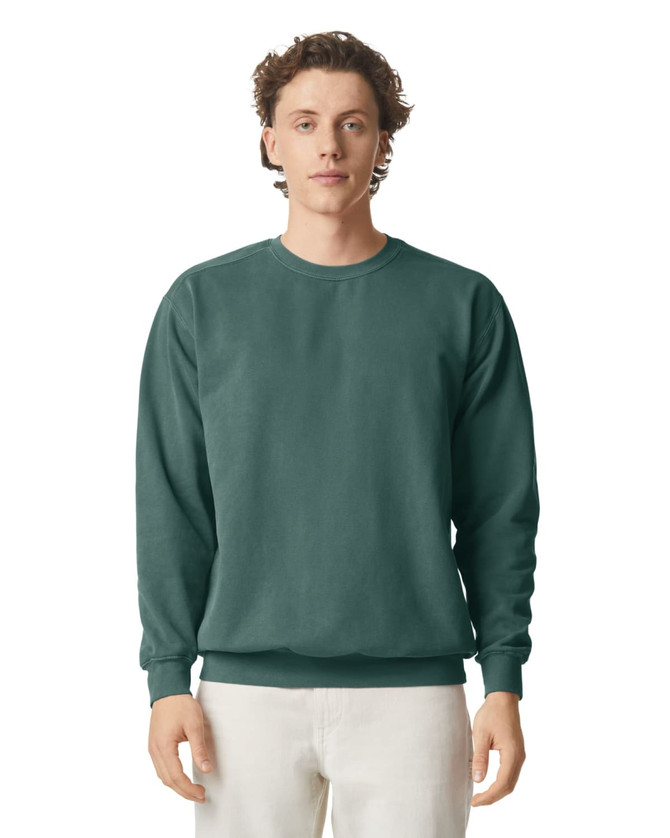 A green crewneck sweatshirt displayed on a model. The sweatshirt features a classic fit and ribbed cuffs.
