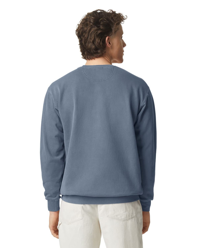 A crewneck sweatshirt in a muted blue colour, featuring a simple design and a logo on the back.