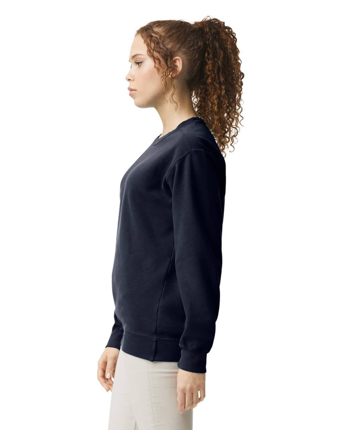 A navy adult crewneck sweatshirt displayed on a model, featuring a classic fit and ribbed cuffs.