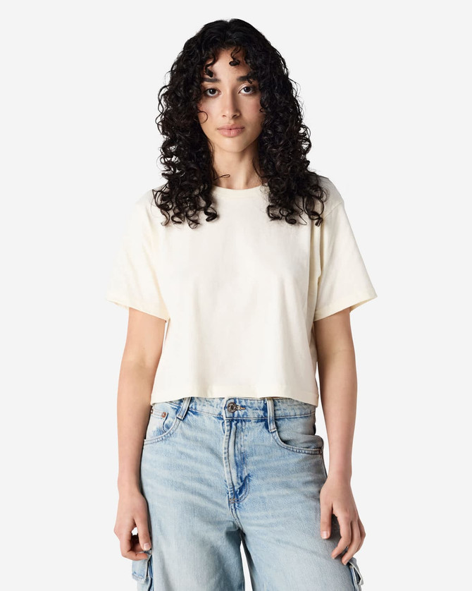 A cream-coloured women's boxy t-shirt with a crew neck and short sleeves, featuring a logo.