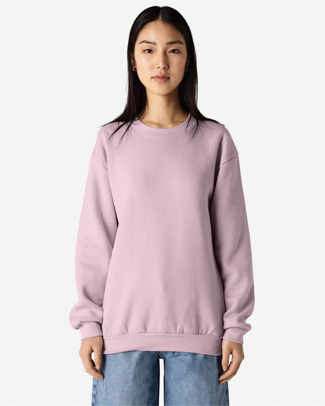 A unisex crewneck sweatshirt in a soft lilac colour, featuring long sleeves and a relaxed fit. It has a small logo.