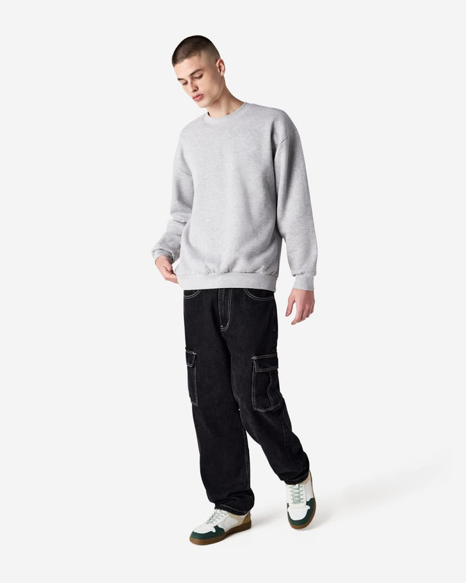 A grey unisex crewneck sweatshirt displayed on a model wearing black cargo pants and sneakers.