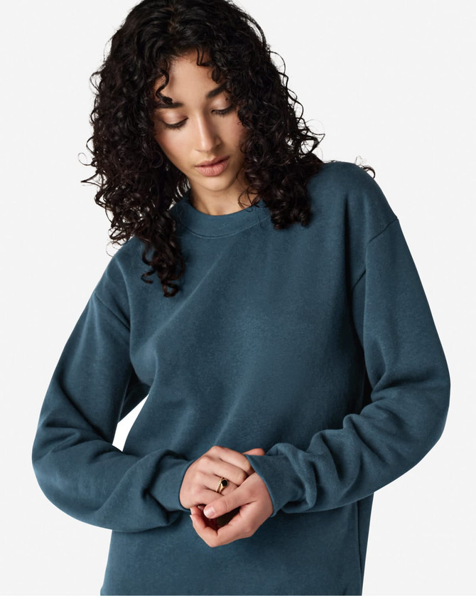 A unisex crewneck sweatshirt in deep teal, featuring long sleeves and a relaxed fit, with a logo present.