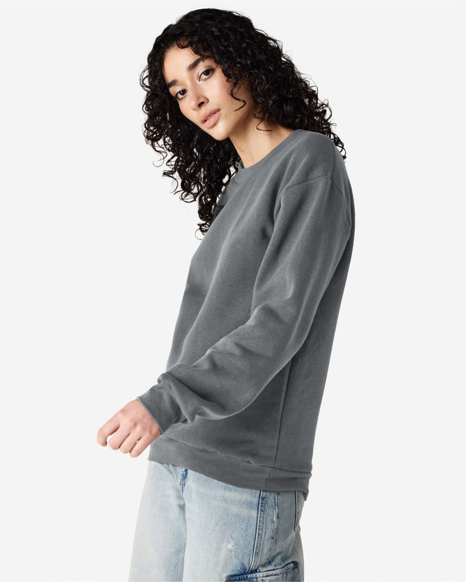 A unisex crewneck sweatshirt in grey, featuring long sleeves and a relaxed fit. It includes a logo.