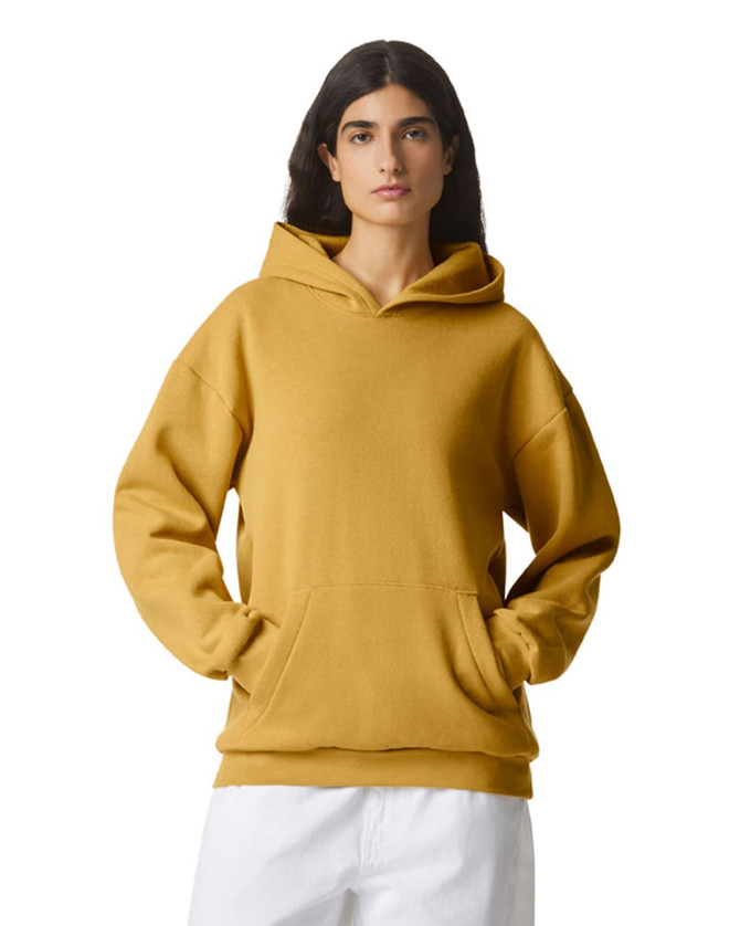 A unisex hooded sweatshirt in mustard yellow with a front pocket and a relaxed fit, featuring a logo.