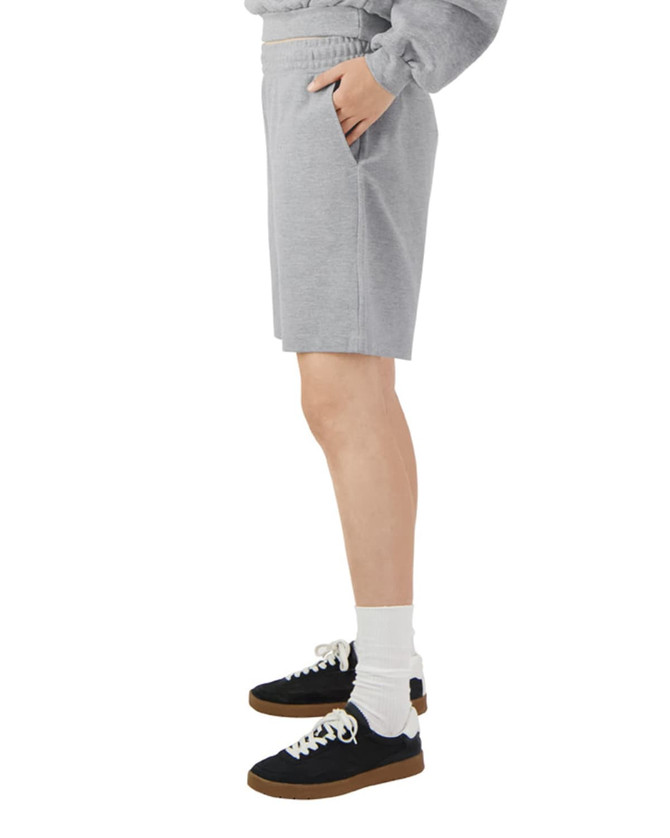 Light grey unisex gym shorts with an elastic waistband and side pockets, displayed on a model from the side.