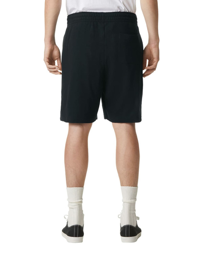 Unisex pique gym shorts in black, featuring an elastic waistband and side pockets, worn with black sneakers and white socks.