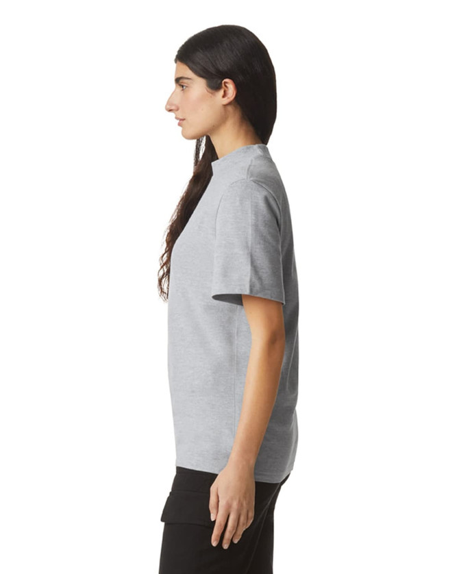 A grey unisex pique mockneck T-shirt with short sleeves, featuring a side view of the model wearing it.